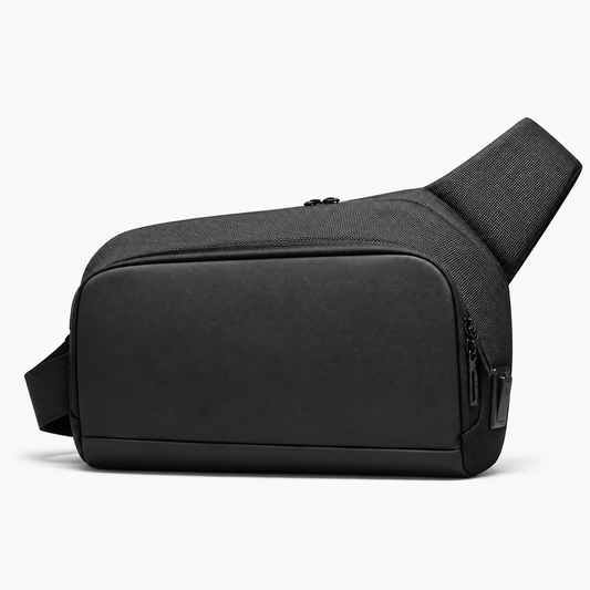 Black Oxford crossbody sling bag with a smooth front panel, zippered compartments and wide shoulder strap on a white background