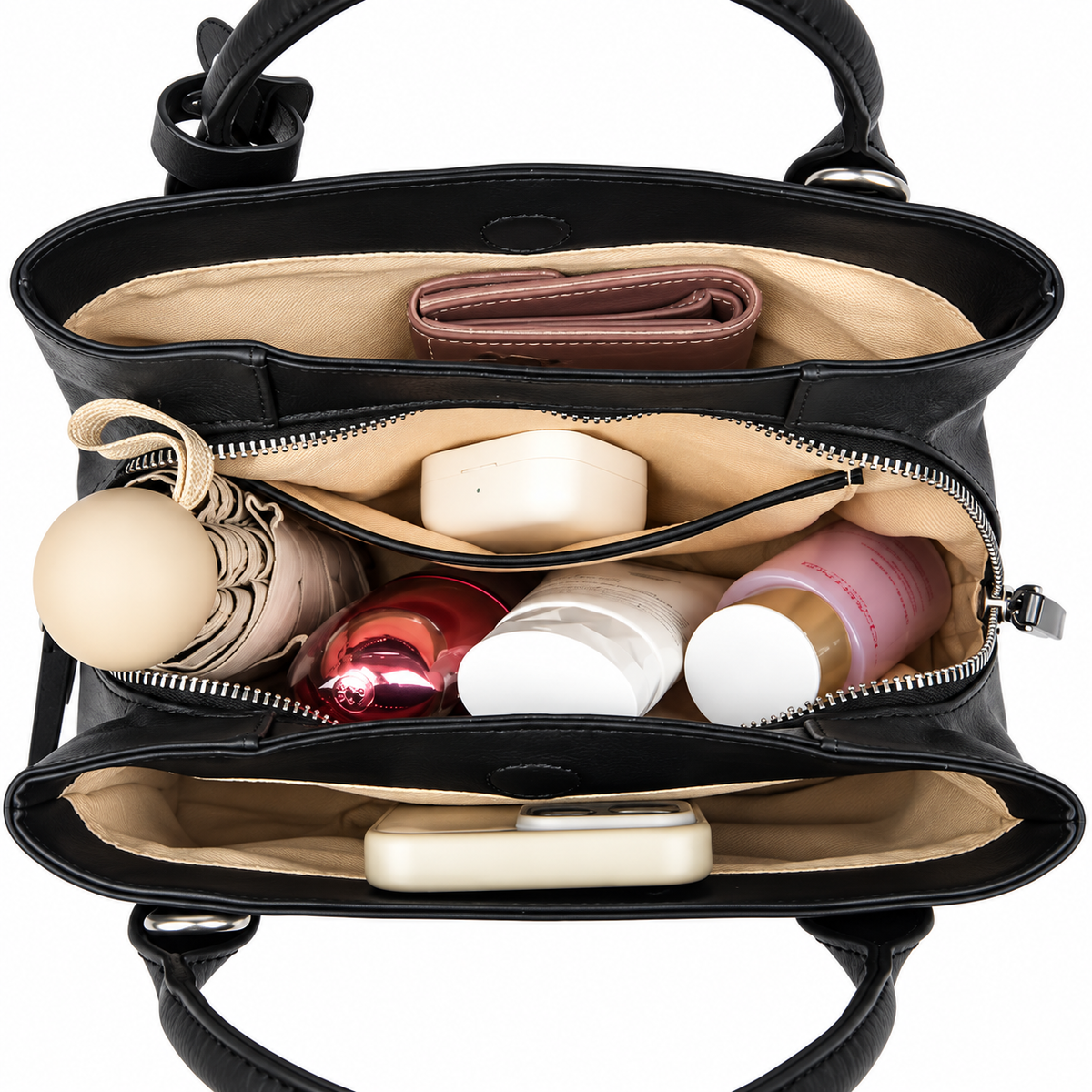 Open black shoulder bag showing beige lining, a central zippered compartment and separate sections holding everyday essentials