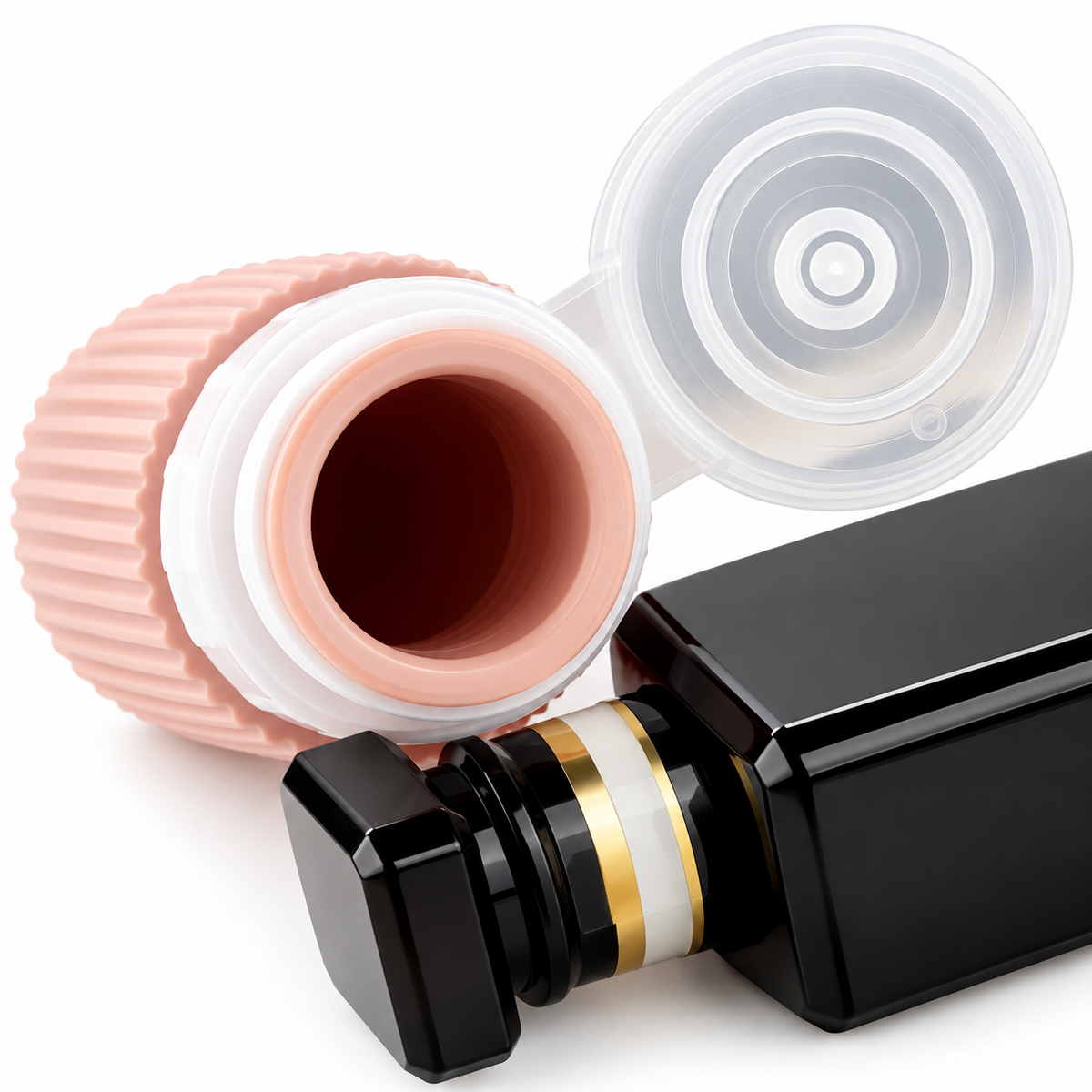 Close-up of a peach silicone travel bottle with its clear flip-top cap open beside a black pump bottle